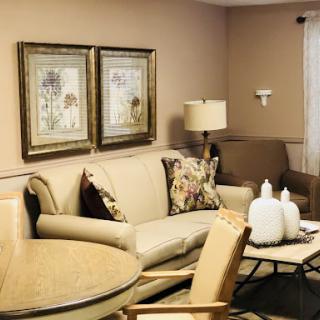 A cozy living room featuring a comfortable sofa, elegant artwork, and stylish decor.