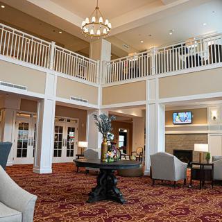 A spacious and elegant hotel lobby with comfortable seating and a chandelier.