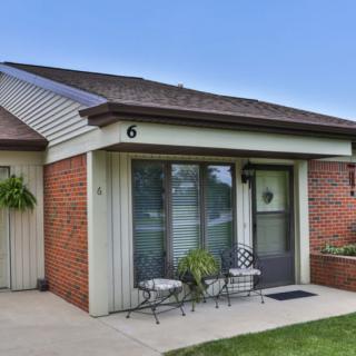 A cozy single-story house with a small front patio area and brick exterior.