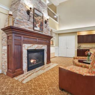 A cozy living room with a large stone fireplace and comfortable seating.