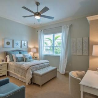 A well-decorated bedroom featuring a comfortable bed, elegant lighting, and soothing color palette.