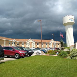 A view of a building with a water tower and dark storm clouds overhead.