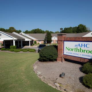 A healthcare facility with a sign reading 'AHC Northbrook' under a clear blue sky.