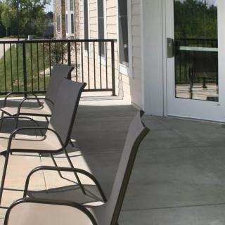 Outdoor patio area with chairs lined up on a balcony.