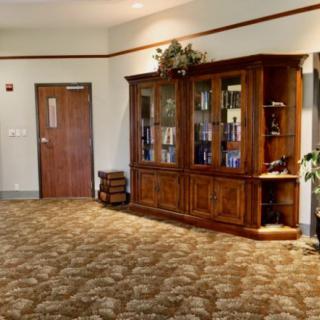 A well-furnished interior with a wooden cabinet and bookshelves, adorned with decorative items.