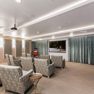 A well-designed home theater room featuring comfortable seating and a large screen.