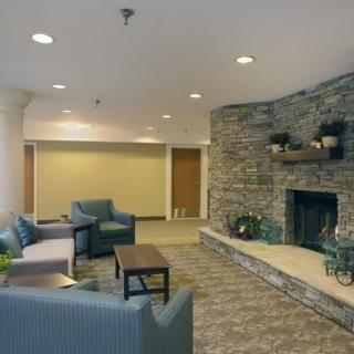 A cozy living room with a stone fireplace and comfortable seating.