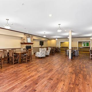 A spacious lounge area featuring wooden floors and comfortable seating.