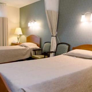 A cozy hotel room with twin beds and warm lighting.