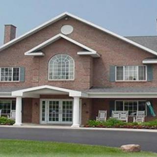 A two-story brick house with a gabled roof and a front porch.