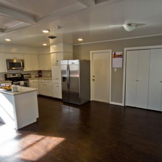 A spacious, modern kitchen with white cabinets and stainless steel appliances.