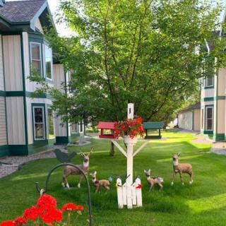 A charming garden scene with decorative animal figures surrounded by lush greenery and residential buildings.