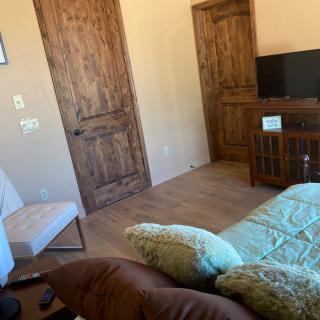 A cozy living room with wooden doors, a television, and comfortable seating.