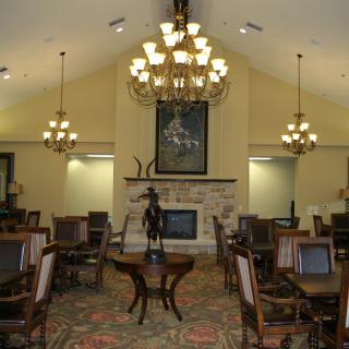 An elegant dining room with chandeliers and a fireplace.