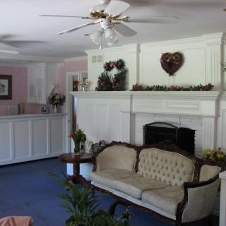 A traditional living room with a sofa, fireplace, and ceiling fan.