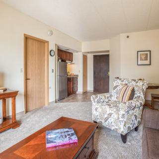A cozy living room with an armchair and a coffee table, showcasing warm and inviting decor.