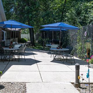 A cozy outdoor patio area with tables and blue umbrellas, perfect for relaxation.