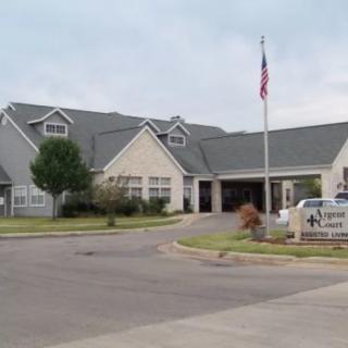 A residential building with an entrance and flagpole in front.