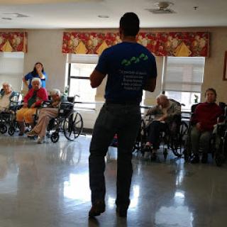 A speaker engages with residents in an assisted living facility.