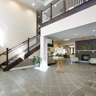 A spacious and modern lobby with a staircase and comfortable seating.
