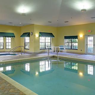 An indoor swimming pool area with large windows and ambient lighting.