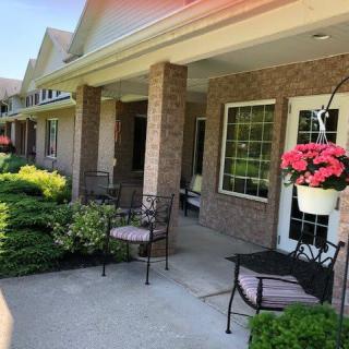 A cozy front porch with chairs and hanging flowers, perfect for outdoor relaxation.