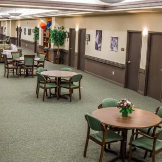 A decorated hallway with tables and chairs arranged for an event.
