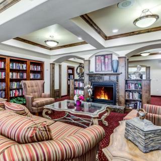 A cozy library space with a fireplace and comfortable seating.