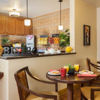 A cozy dining area with a well-set table, adjacent to a kitchen.