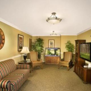 A cozy living room with comfortable seating, a television, and an aquarium.
