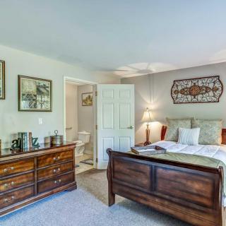 A cozy bedroom with a wooden bed, dresser, and decorative artwork on the walls.