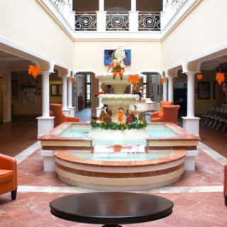A beautifully decorated lobby with a central fountain surrounded by seating and architectural columns.