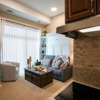 A modern living room with a cozy sofa, coffee table, and adjacent kitchen.