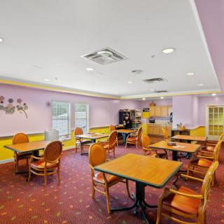 A cozy indoor dining area with tables and chairs, featuring a warm color scheme.