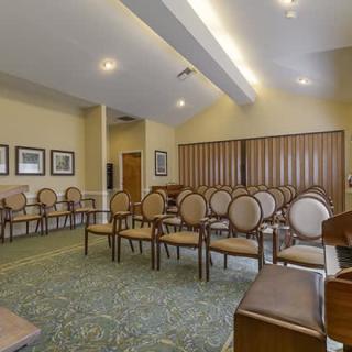 An empty conference room with neatly arranged chairs and wall art.