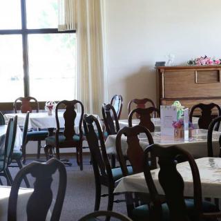 An empty restaurant dining area with neatly arranged tables and chairs.