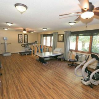 A spacious home gym with various fitness equipment and ample natural light.