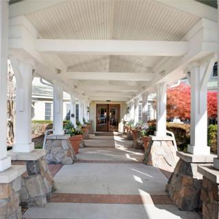 A covered walkway with stone pillars leading to an entrance.