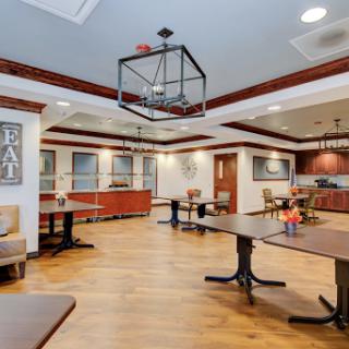A spacious and elegantly designed dining area featuring modern furniture and warm lighting.