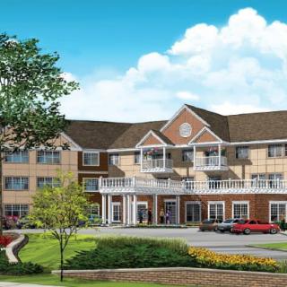 A large, elegant residential building with manicured landscaping and a bright blue sky.