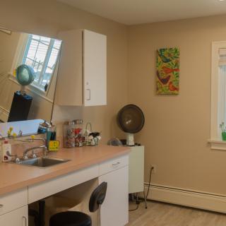 A tidy and minimalist office space with a desk, mirror, and window.