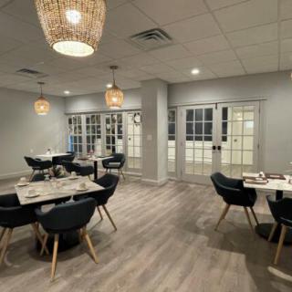A modern dining area with stylish lighting and wood flooring.