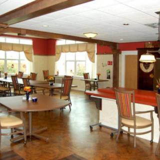 A cozy and well-lit dining area with tables, chairs, and large windows.