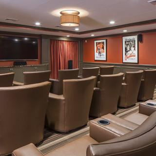 A cozy home theater with comfortable leather seating and a large projector screen, perfect for watching movies.