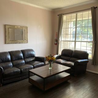 A cozy living room with leather sofas and a large window.