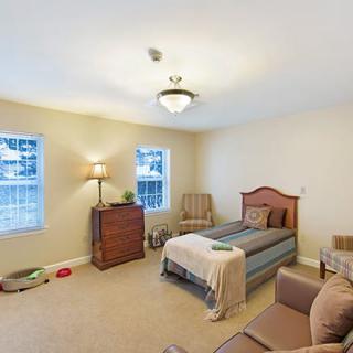 A cozy bedroom with a single bed and simple furnishings.