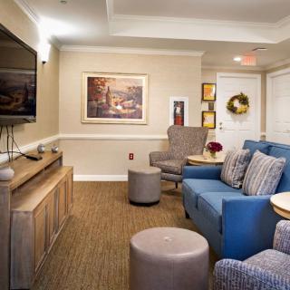 A cozy living room with comfortable seating, a television, and decorative artwork on the walls.