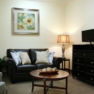 A cozy living room with a leather sofa, coffee table, and wall art.