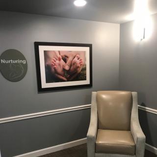 A cozy hallway with a comfortable chair and framed artwork on the wall.