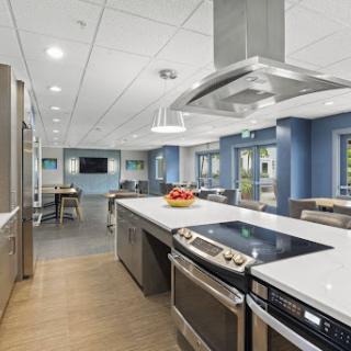 A modern kitchen featuring an island with a cooktop, stainless steel appliances, and contemporary decor.